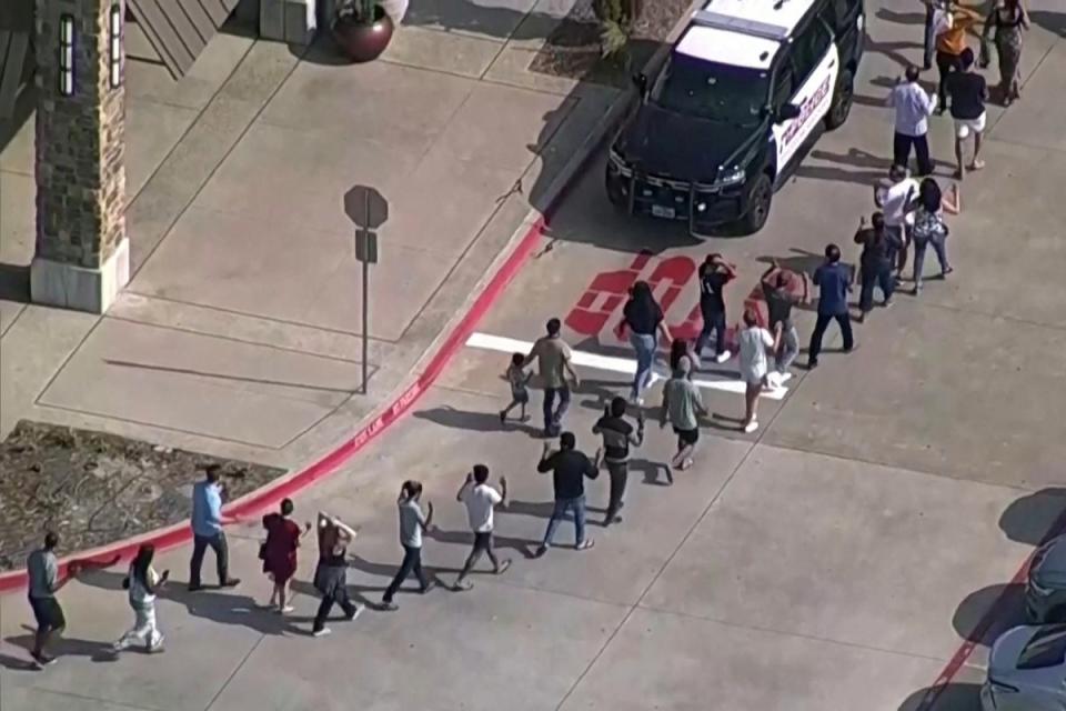 Survivors of the Allen mall mass shooting are escorted away from the scene by police officers. (via REUTERS)