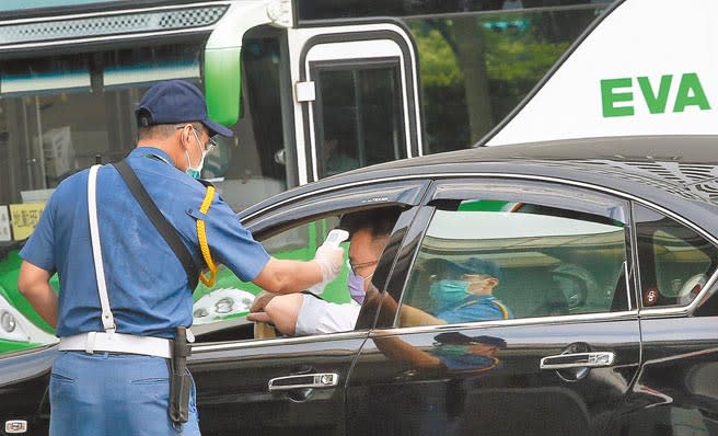 長榮航空3機師染疫引發各界關注，民航局長對業者說重話，無法落實防疫就檢討航線。長榮航空昨日召回283名匡列人員，前往南崁總部做PCR篩檢，在總部大門前，保全人員為進入總部的員工量測體溫。（范揚光攝）