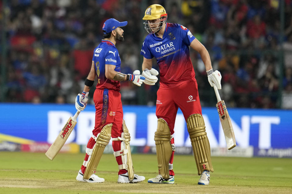 Royal Challengers Bengaluru's Cameron Green, right, listens to batting partner Virat Kohli after hitting a boundary during the Indian Premier League cricket match between Royal Challengers Bengaluru and Kolkata Knight Riders in Bengaluru, India, Friday, March 29, 2024. (AP Photo/Aijaz Rahi)