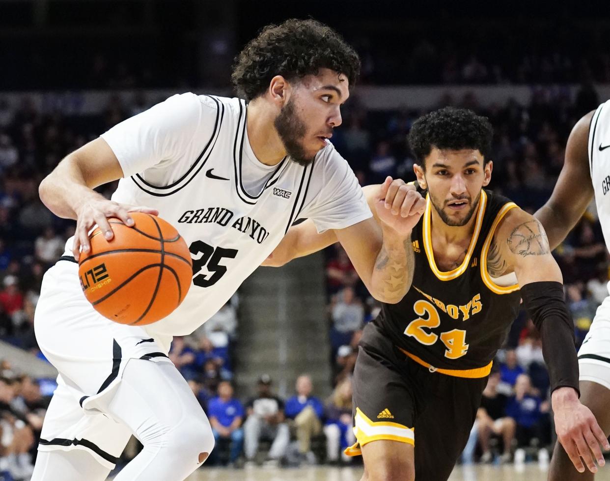 Nov 22, 2021; Phoenix, Arizona, USA; Grand Canyon Antelopes forward Taeshon Cherry (35) drives against Wyoming Cowboys guard Hunter Maldonado (24) at GCU Arena. Mandatory Credit: Rob Schumacher-Arizona Republic