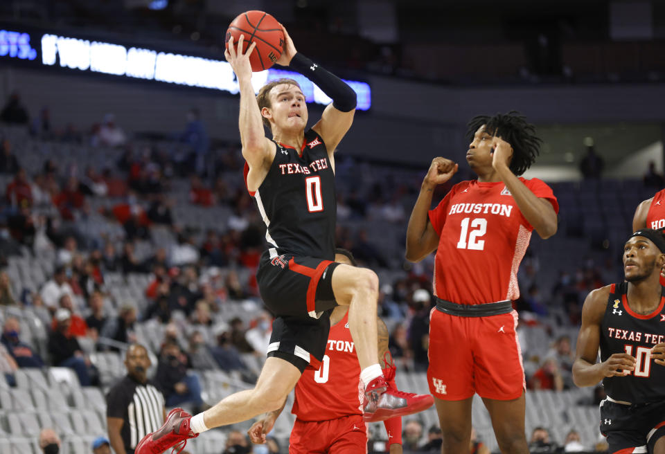 Texas Tech guard Mac McClung (0) drives inside as Houston guard Tramon Mark (12) defends during the first half of an NCAA college basketball game, Sunday, Nov. 29, 2020, in Fort Worth, Texas. (AP Photo/Ron Jenkins)