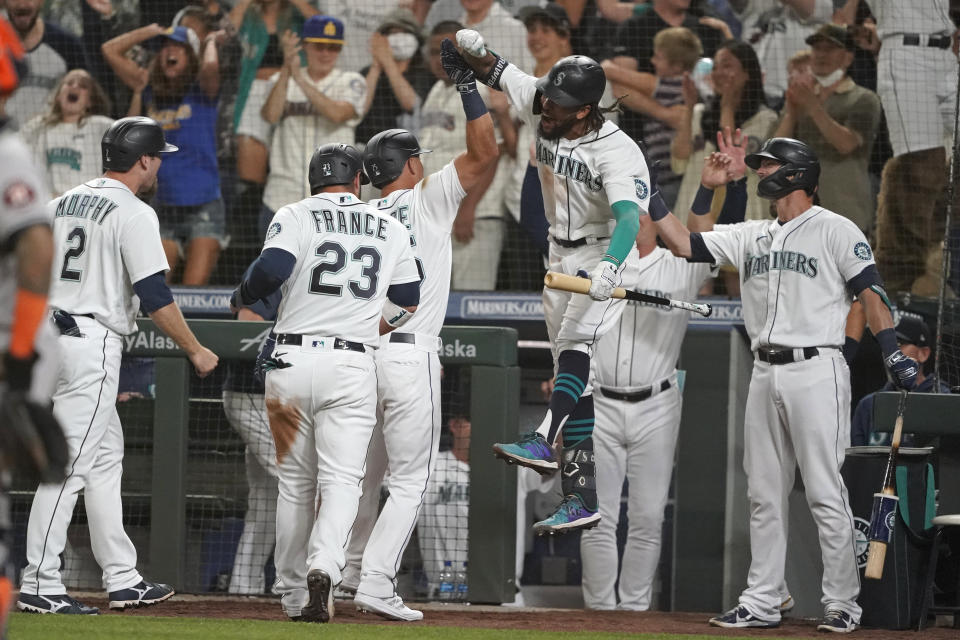 Seattle Mariners' Dylan Moore, third from left, is greeted by J.P. Crawford, center, after Moore hit a grand slam during the eighth inning of a baseball game against the Houston Astros, Monday, July 26, 2021, in Seattle. (AP Photo/Ted S. Warren)