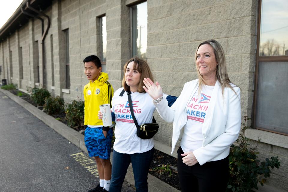 Rachel Baker, the Democratic candidate for Ohio House District 27, waives to voters while standing next to Nora Burke Wagner outside a polling location in Cincinnati on Tuesday, Nov. 8, 2022.