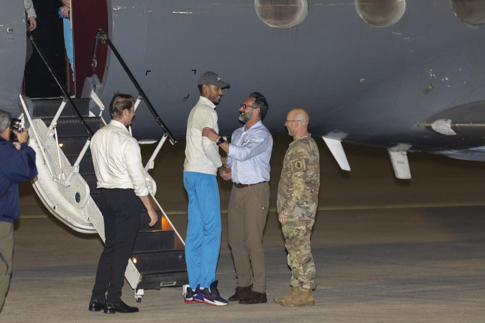 National Security Council Director for Counter Terrorism David Cotter, left, with Special Presidential Envoy for Hostage Affairs Ambassador Rodger Carstens and Col. Mark Davis greet freed American Savoi Wright as he exits a State Department plane at Kelly Airfield Annex, Wednesday, Dec. 20, 2023, in San Antonio, Texas. The United States has freed a close ally of Venezuelan President Nicolás Maduro in exchange for the release of 10 Americans, including Savoi Wright, who were imprisoned in the South American country and the return of a fugitive defense contractor. Six of the Americans released arrived at Kelly Airfield Annex. (AP Photo/Stephen Spillman)