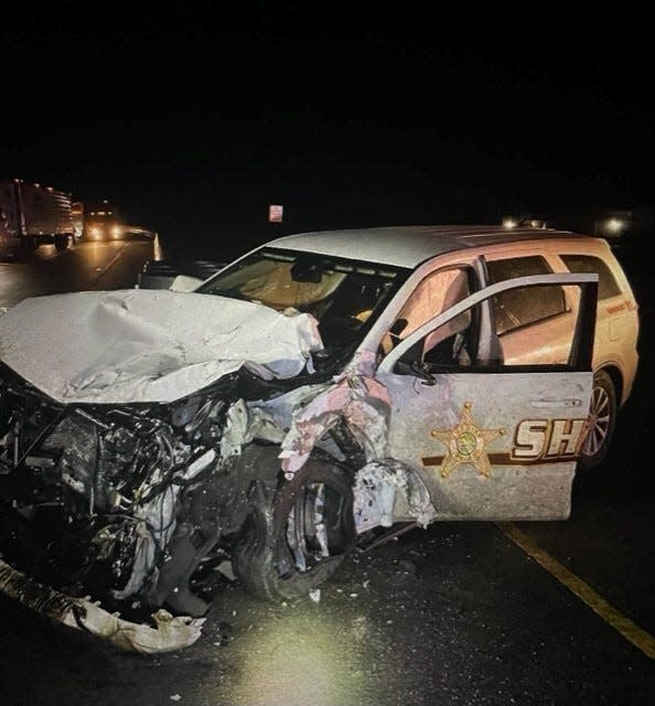 SPICELAND -- A crumpled Henry County Sheriff's patrol vehicle sits along the highway at the intersection of Ind. 3 and Interstate 70 Thursday night after the vehicle collided with a semi-truck. The crash sent two Henry County deputies and the truck driver to the hospital with non-life threatening injuries.