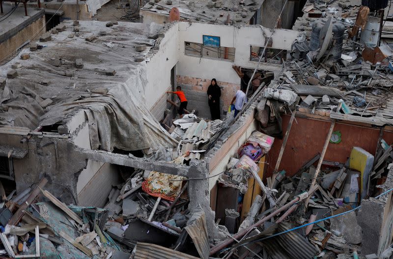 Palestinos comprueban los daños en un lugar donde se produjeron ataques israelíes contra viviendas, en medio del actual conflicto entre Israel y el grupo islamista palestino Hamás, en Jan Yunis