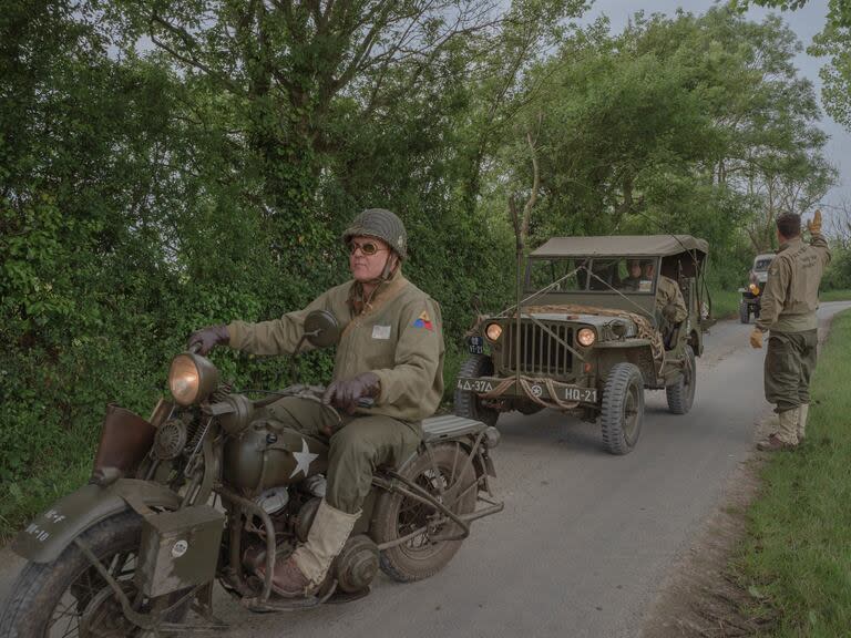 Recreadores vestidos y equipados como en la Segunda Guerra Mundial durante un tour histórico en Normandía 