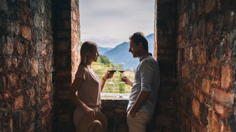 Couple toasting at winery window