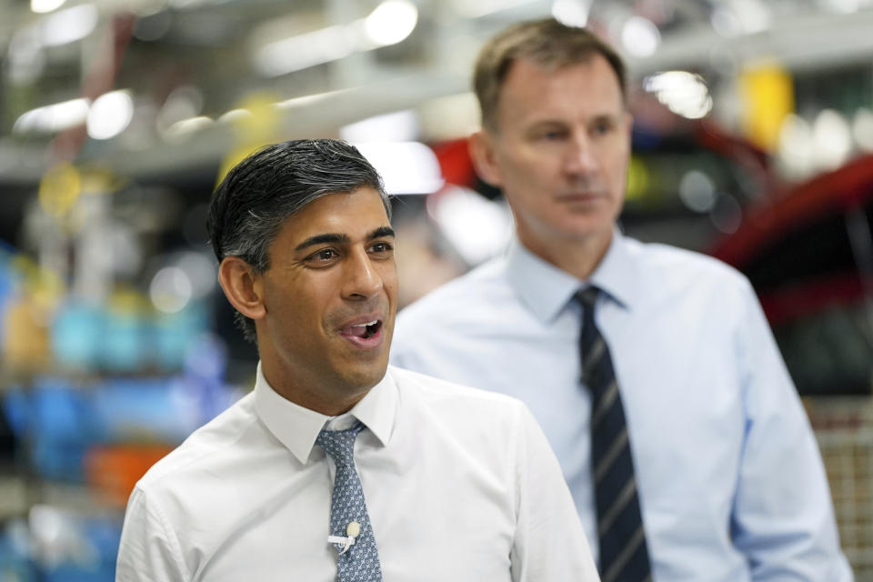 Britain's Prime Minister Rishi Sunak, foreground and Chancellor of the Exchequer Jeremy Hunt visit the car manufacturer Nissan, in Sunderland, England, Friday, Nov. 24, 2023. Nissan will invest more than $1.3 billion to update its factory in northeast England to make electric versions of its two best-selling cars. It's a boost for the British government as it tries to revive the country’s ailing economy. The Japanese automaker manufactures the gasoline-powered Qashqai and smaller Juke crossover vehicles at the factory in Sunderland, which employs 6,000 workers. Ian Forsyth/Pool Photo via AP)