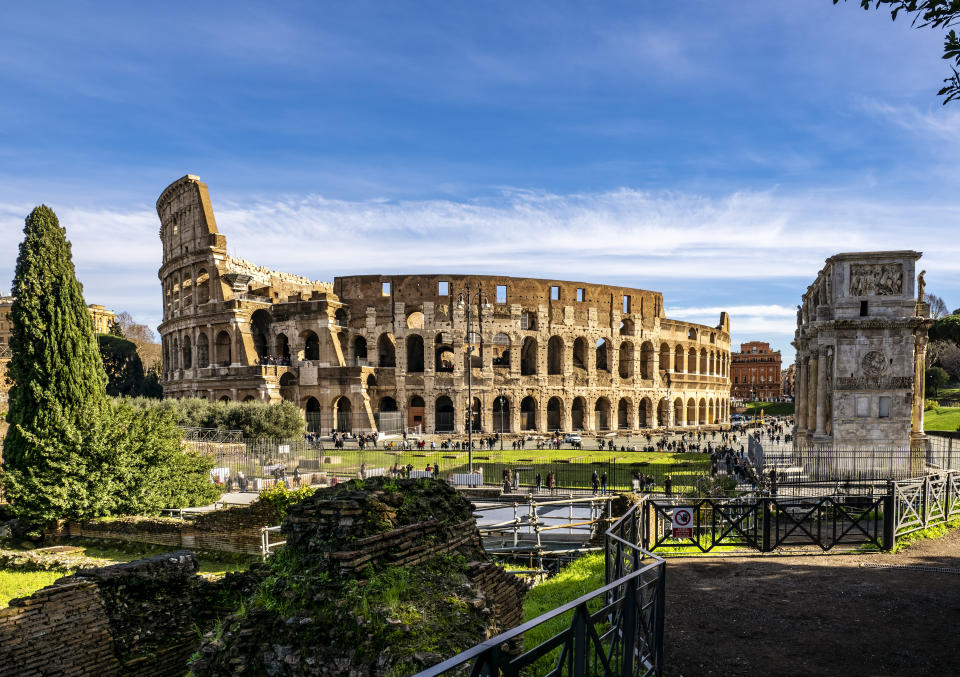 Vista del exterior del Coliseo Romano y del Arco de Constantino, un anfiteatro de la época del Imperio Romano, construido en el siglo I.  En la antigüedad albergó a unos 65.000 espectadores, con ochenta filas de gradas.  El Coliseo ha sido incluido en la Lista del Patrimonio Mundial de la UNESCO desde 1980. Ciudad de Roma, Lazio, Italia, Europa.