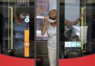 People wear face masks to protect against the coronavirus as they travel by public transport in Vienna, Austria, Wednesday, July 15, 2020. (AP Photo/Ronald Zak)