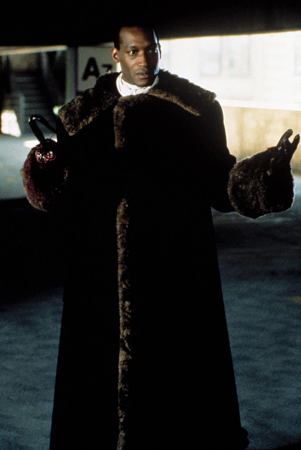 Candyman wearing a long fur coat with his arms open