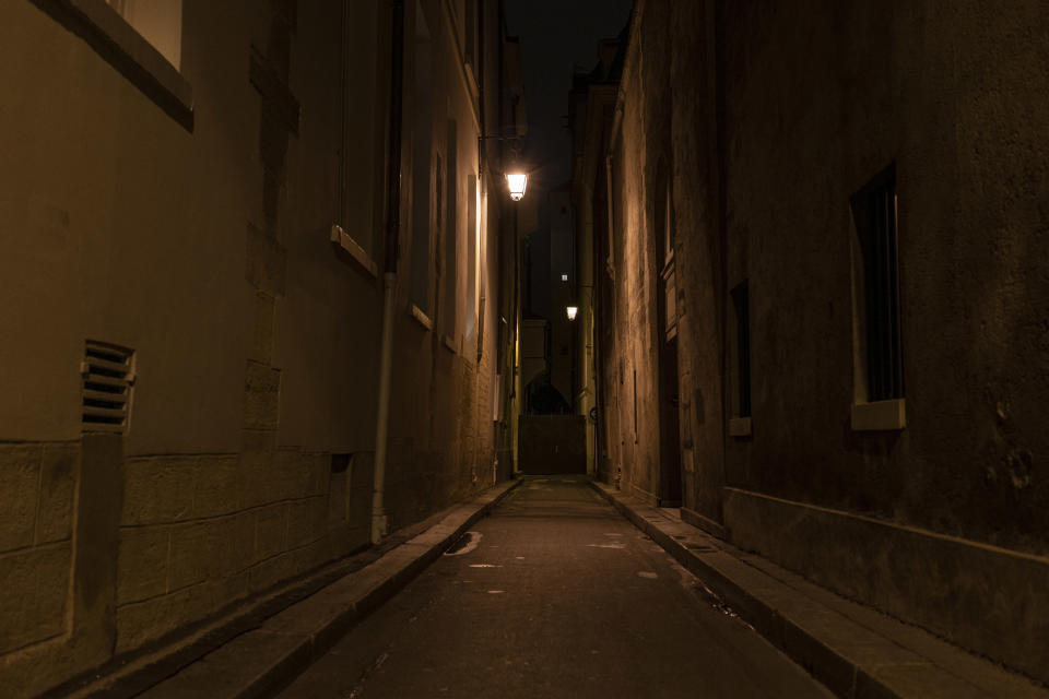 A dark alley at night with only dim lighting.