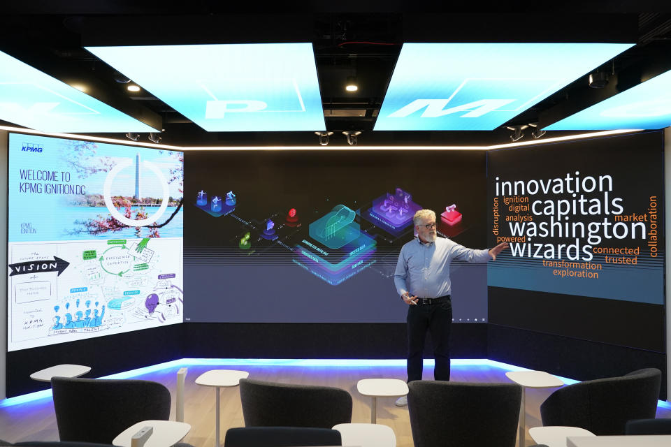 John Hair, director of Insights Centers at KPMG, demonstrates interactive screens in a new business suite at Capital One Arena, home to NHL's Washington Capitals and NBA's Washington Wizards, Tuesday, June 7, 2022, in Washington. (AP Photo/Patrick Semansky)