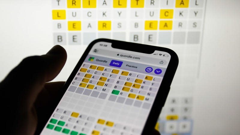 A photo shows someone playing Quordle on their phone. 
