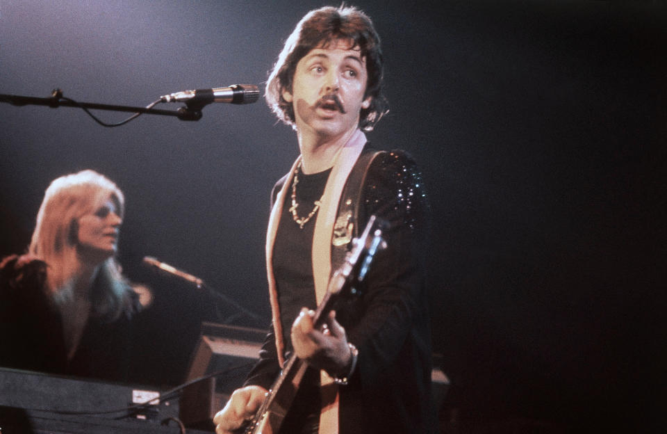 Former Beatle Paul McCartney, with wife Linda in background, on the opening night of his three sold-out concerts at London's Empire Pool, Wembley on October 19, 1976. (AP Photo/John Glanville)