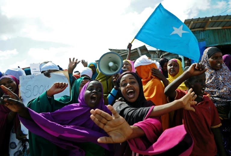 Demonstrators hold placards during a protest against Al Shebab insurgents outside Lido beach in the Somali capital Mogadishu, on January 28, 2016