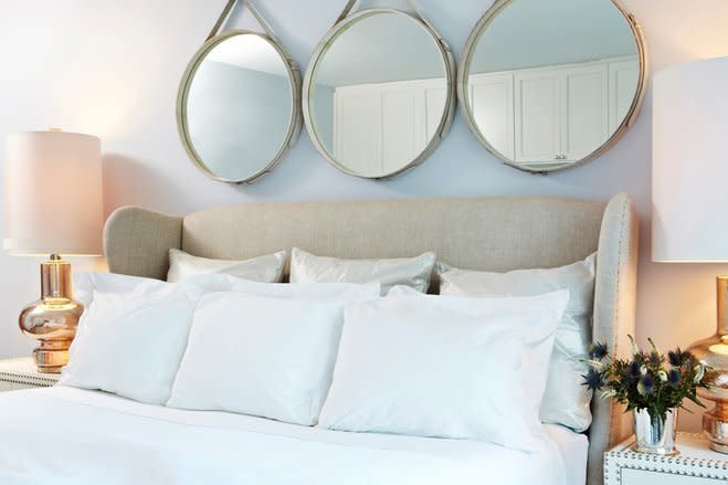 For a design touch that'll also make your bedroom appear bigger, try hanging bold <a href="https://www.wayfair.com/keyword.php?keyword=round+hanging+mirrors&amp;command=dosearch&amp;new_keyword_search=true" target="_blank">mirrors above the bed</a>.&nbsp;