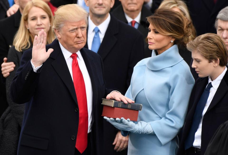 Donald Trump takes the oath of office while standing with Melania Trump and Barron Trump, during the 2017 Presidential Inauguration at the U.S. Capitol.