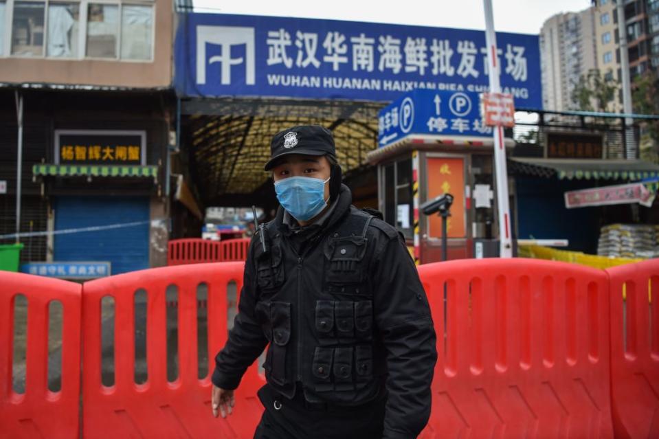 A police officer stands guard outside of Huanan Seafood Wholesale market where the coronavirus is believed to have originated. Source: Getty