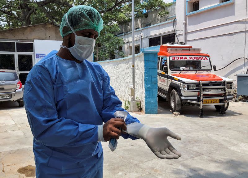 Mohammad Aamir Khan, an ambulance driver, wears his personal protective equipment at a mortuary, before transporting bodies of people who died due to the coronavirus disease, to a graveyard in New Delhi