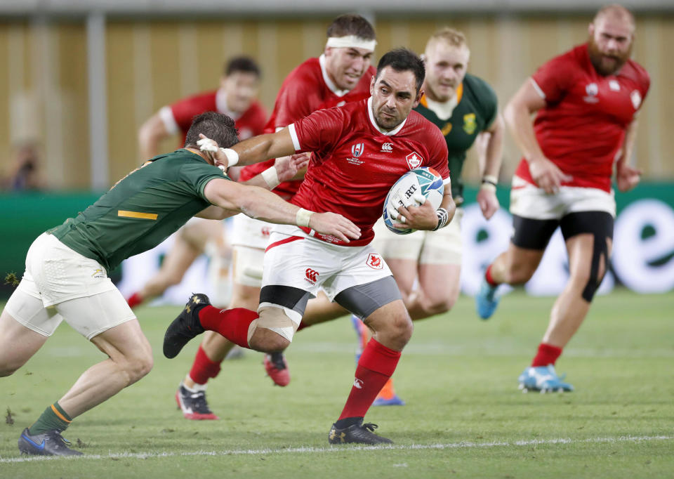 Canada's Phil Mack attempts to run past a South African defender during the Rugby World Cup Pool B game at Kobe Misaki Stadium between South Africa and Canada in Kobe, Japan, Tuesday, Oct. 8, 2019. (Kyodo News via AP)