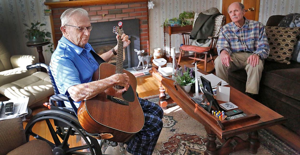 Tom plays his guitar for longtime friend Bob Leatherbee, of Kingston, who was also a crane operator.