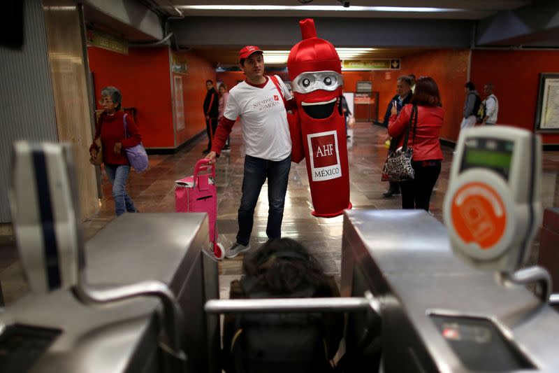 A man carries a condom costume inside the metro on International Condoms Day, celebrated a day before Valentine Day, in Mexico City