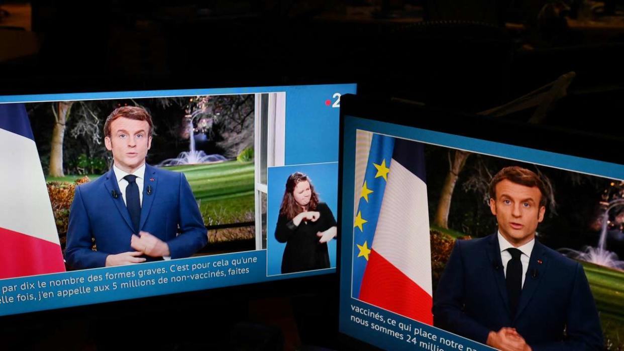 Des images du président français Emmanuel Macron sont vues sur des écrans d’ordinateur alors qu’il prononce son discours télévisé du Nouvel An à la nation depuis le palais de l’Élysée, à Paris, le 31 décembre 2021. (Photo : Martin BUREAU / AFP)