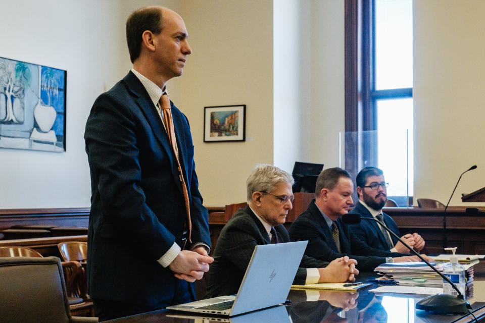 Attorney Thomas Anger, representing the office of the Ohio Auditor of State, addresses the court during a change of plea hearing for William G Timberlake, third from left, flanked by his attorneys.
