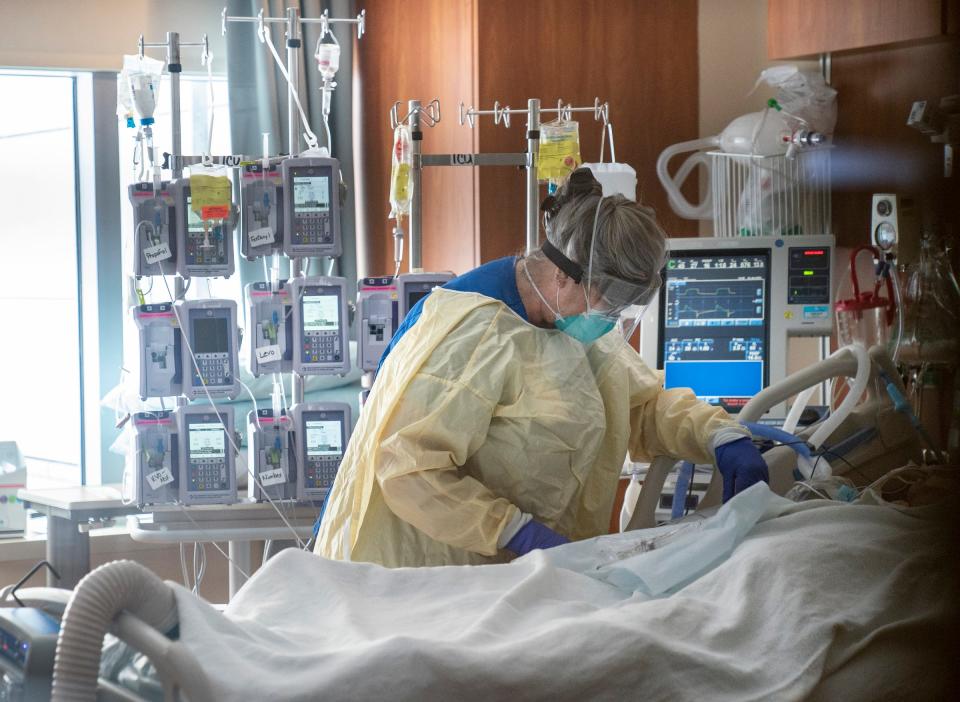 Dee Tait, an RN in the ICU at St. Joseph Mercy Oakland Hospital in Pontiac, tends to an intubated COVID patient on Monday, Jan. 24, 2022.  