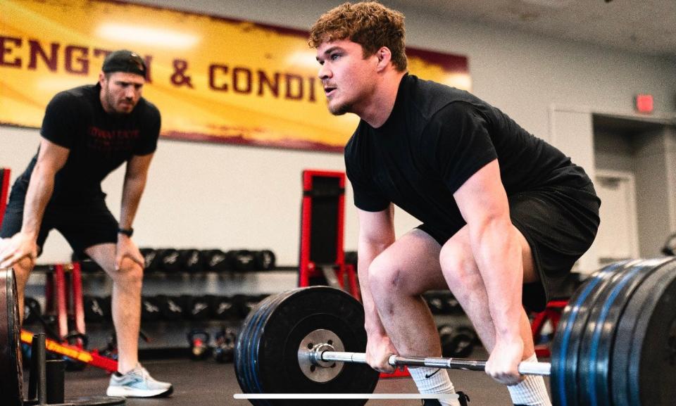 Ben Durbin, the Iowa State wrestling team's strength and conditioning coach, is pictured here helping Cyclone wrestler Cody Fisher through a workout.