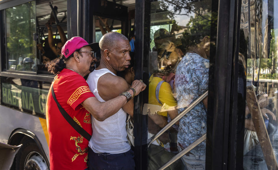 La gente empuja para subirse a un autobús completamente lleno de clientes en La Habana, Cuba, el jueves 6 de abril de 2023. (AP Foto/Ramón Espinosa)