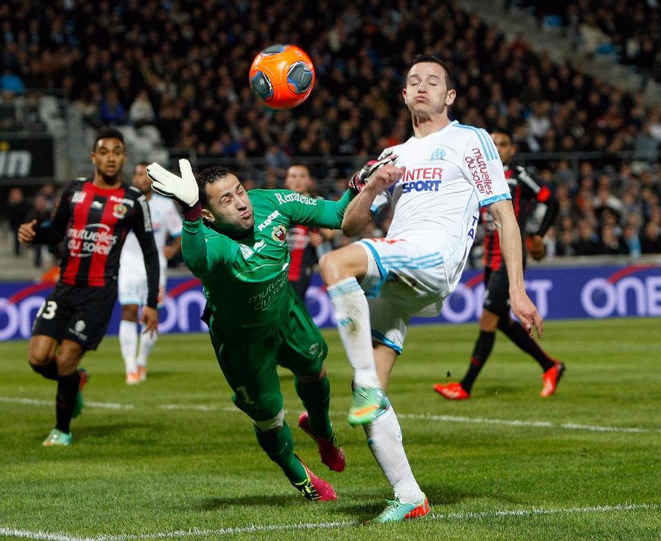 Marseille's French midfielder Florian Thauvin, right, challenges for the ball with Nice's Colombian goalkeeper David Ospina, during their League One soccer match, at the Velodrome Stadium, in Marseille, southern France, Friday, March 7, 2014. (AP Photo/Claude Paris)