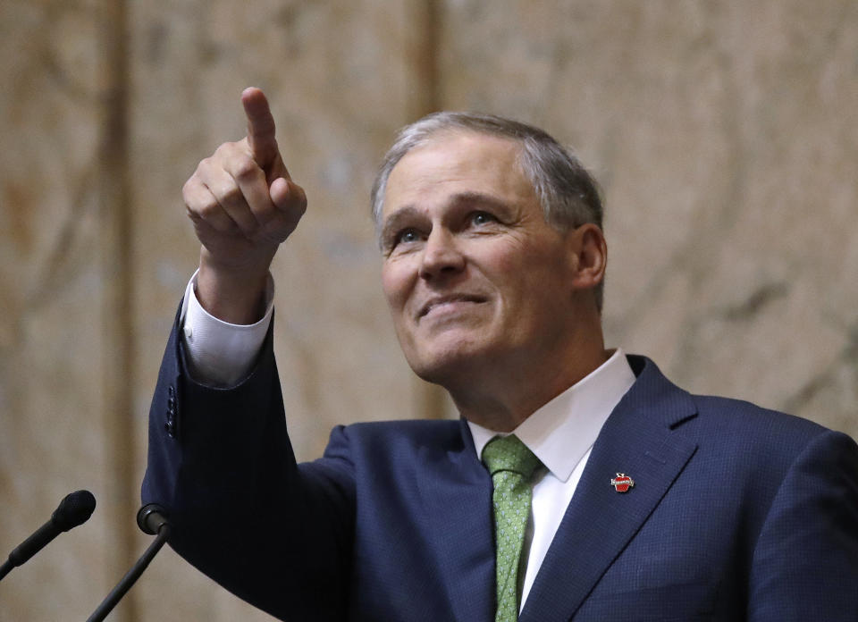 FILE- in this Jan. 15, 2019 file photo Washington Gov. Jay Inslee points toward the gallery above where his family sits at the conclusion of his State of the State address in Olympia, Wash. The governors of Michigan, New York and Washington are asking the Trump administration to let states offer unemployment benefits to federal employees who are working without pay during the government shutdown that began nearly a month ago. (AP Photo/Elaine Thompson File)