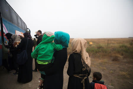 Syrians wait to board a bus just after they crossed the armistice line from Syria to the Israeli-occupied Golan Heights to get medical treatment in Israel, July 11, 2018. REUTERS/ Ronen Zvulun