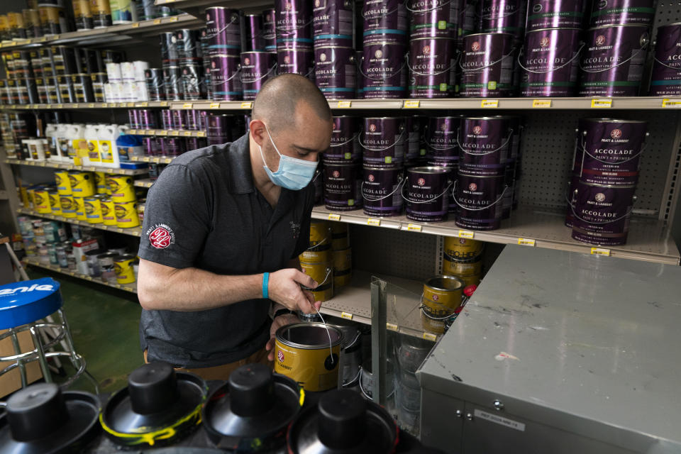 Billy Wommack, purchasing director at the W.S. Jenks & Sons hardware, carries a gallon of paint to a shaker at the mixing station of the hardware store's paint department, Friday, Sept. 24, 2021, in northeast Washington. The chemical shortages, and a near doubling of oil prices in the past year, mean higher prices for many goods. The W.S. Jenks & Son hardware store is only getting 20% to 30% of paint it needs to meet customer demand without backordering; in normal times the so-called fill rate usually runs 90%. (AP Photo/Manuel Balce Ceneta)