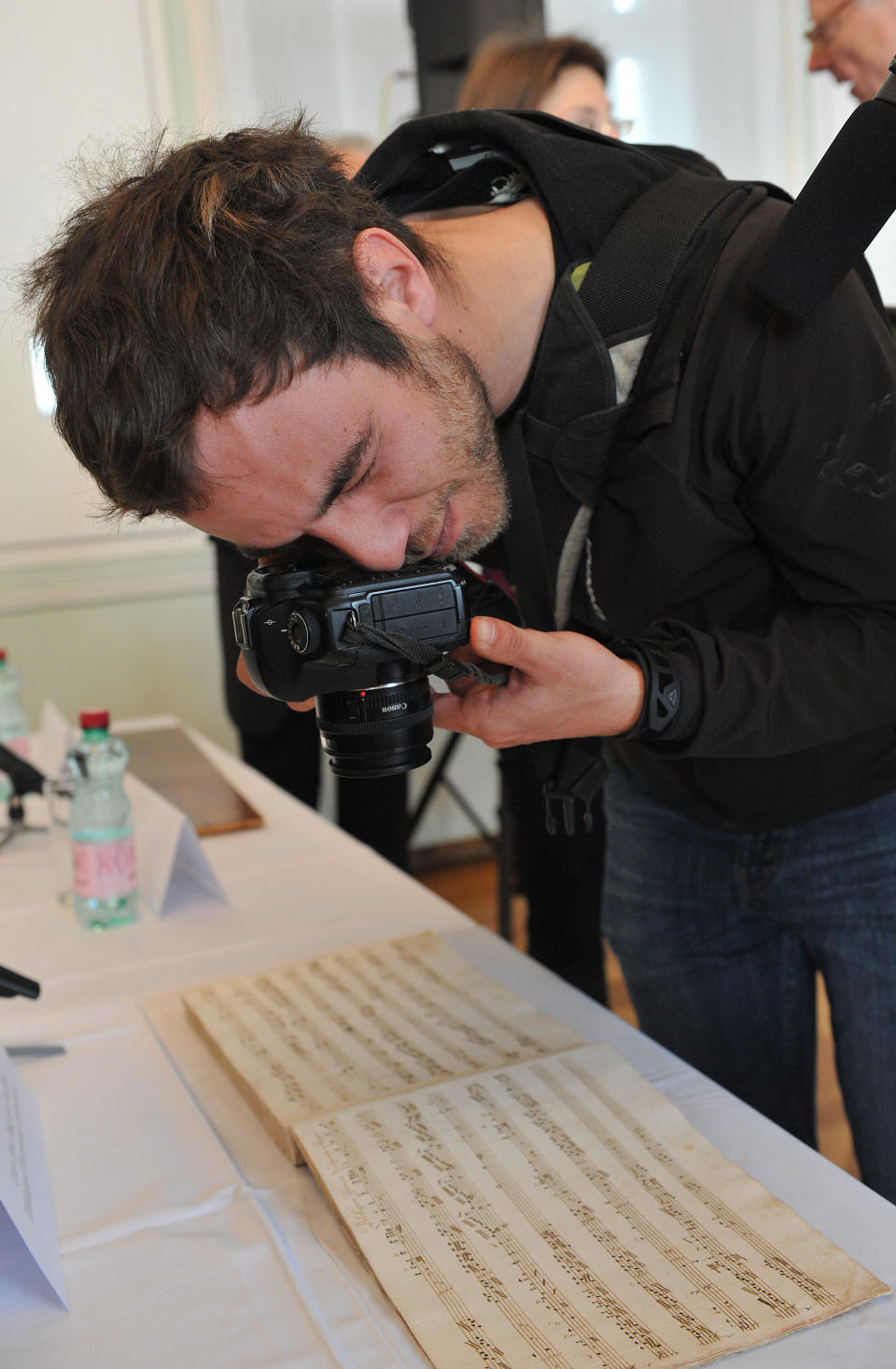 A photographer takes images of a sheet of music, recently identified as a composition by Wolfgang Amadeus Mozart, during a press conference held by the research department of the International Mozarteum Foundation in Salzburg, Austria, Friday, March 23, 2012. The previously unknown piano piece from Mozart has been discovered in Tyrol in Austria. The Mozart Foundation in Salzburg says that the piece was found in a hand written music book from 1780. (AP Photo/ Kerstin Joensson)