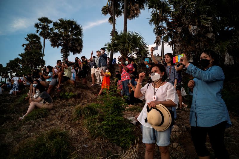 FILE PHOTO: Locals and tourists watch a sunset from Phuket Island's Phromthep Cape