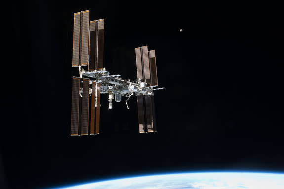 This picture of the International Space Station and the moon was photographed from the space shuttle Atlantis just after the two spacecraft undocked on July 19, 2011, during NASA's final shuttle mission STS-135.