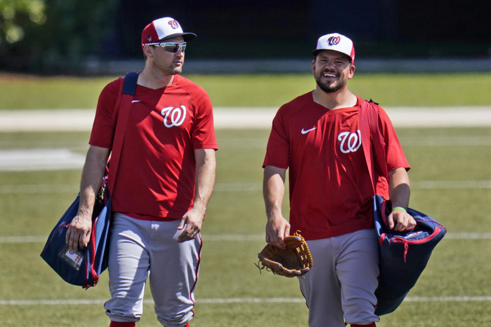 Washington Nationals' Ryan Zimmerman, left, walks toward the clubhouse with teammate Kyle Schwarber at the end of spring training baseball practice Thursday, Feb. 25, 2021, in West Palm Beach, Fla. (AP Photo/Jeff Roberson)