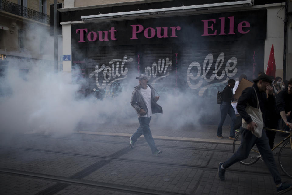 A protester reacts to tear gas fired by French riot police during a march against police brutality and racism in Marseille, France, Saturday, June 13, 2020, organized by supporters of Adama Traore, who died in police custody in 2016. Several demonstrations went ahead Saturday inspired by the Black Lives Matter movement in the U.S. (AP Photo/Daniel Cole)