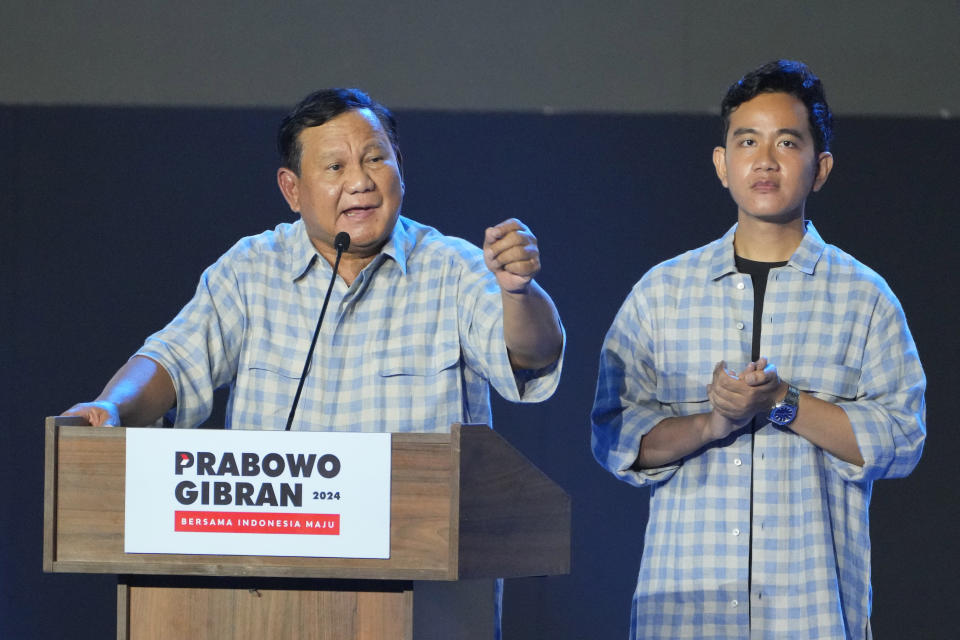 Presidential candidate Prabowo Subianto, left, speaks to supporters and members of his campaign team as his running mate Gibran Rakabuming Raka, the eldest son of Indonesian President Joko Widodo, looks on in Jakarta, Indonesia, Wednesday, Feb. 14, 2024. Defense Minister Prabowo Subianto claimed victory in Indonesia's presidential election on Wednesday based on unofficial tallies, proclaiming it a victory for all Indonesian people. (AP Photo/Vincent Thian)