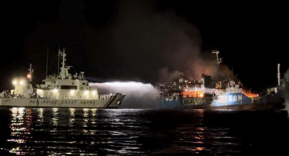 In this photo provided by the Philippine Coast Guard, a Philippine Coast Guard ship trains its hose as it tries to extinguish fire on the MV Lady Mary Joy at Basilan, southern Philippines early Thursday March 30, 2023. Multiple people died and others were missing after an inter-island cargo and passenger ferry with more than 200 passengers and crew onboard caught fire close to midnight in the southern Philippines, a provincial governor said Thursday. (Philippine Coast Guard via AP)