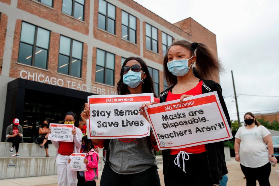 Protesters hold signs during the Occupy City Hall Protest and Car Caravan hosted by Chicago Teachers Union in Chicago.