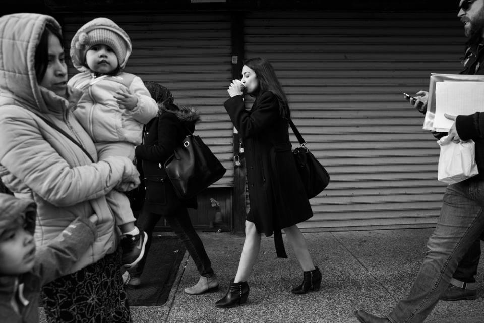 Ocasio-Cortez, sips a coffee on the way back to her district office in Jackson Heights.