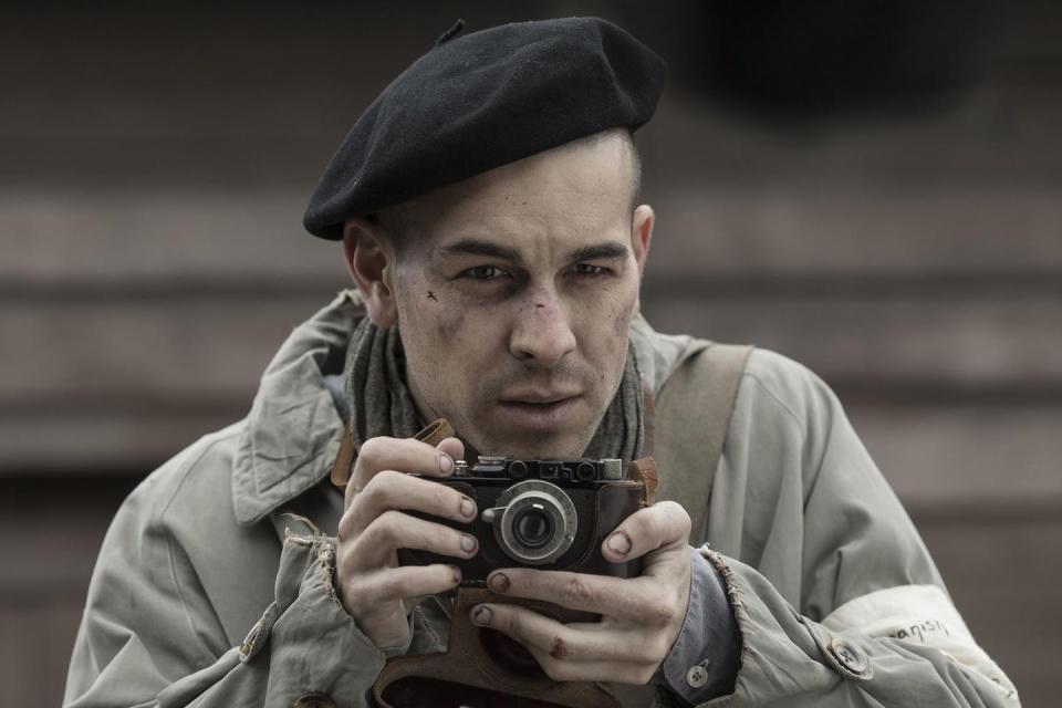 Un hombre demacrado en uniforme hace una fotografía.