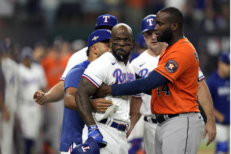 Texas Rangers' Adolis Garcia is restrained by teammates and Houston Astros' Yordan Alvarez (44) after being hit by a pitch during the eighth inning in Game 5 of the baseball American League Championship Series Friday, Oct. 20, 2023, in Arlington, Texas. (AP Photo/Godofredo A. Vásquez)