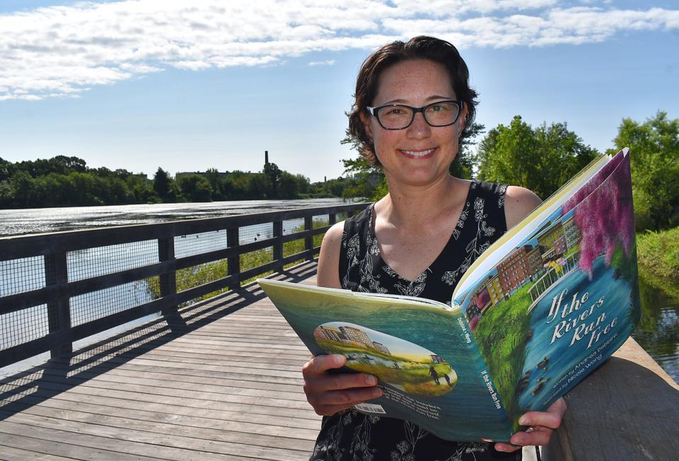 Fall River resident and children's book illustrator Nicole Wong holds a copy of "If the Rivers Run Free," by Andrea Debbink, releasing on Aug. 15 from Sleeping Bear Press. Wong created the illustrations for the book.