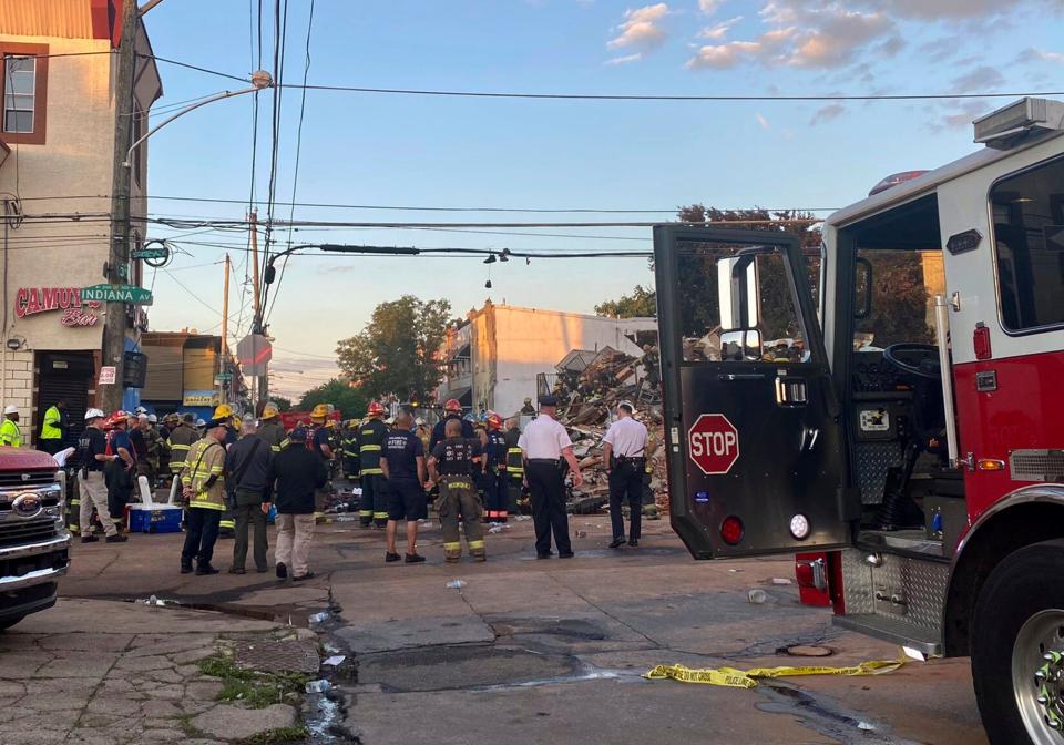 This photo provided by the Philadelphia Fire Dept., emergency personnel respond to the scene of a building that caught fire then collapsed early Saturday, June 18, 2022 in Philadelphia.  The Philadelphia Fire Department said several firefighters and a city inspector became trapped when a building collapsed during a fire response early Saturday, with more than one person still under the rubble hours later. (Philadelphia Fire Dept. via AP)